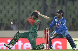 Bangladesh cricketer Taskin Ahmed (L) plays a shot as Indian crikcet captain Mahendra Singh Dhoni looks on during the Asia Cup T20 cricket match between India and Bangladesh at Sher-e-Bangla National Cricket Stadium in Dhaka on February 24, 2016. / AFP / MUNIR UZ ZAMAN        (Photo credit should read MUNIR UZ ZAMAN/AFP/Getty Images)